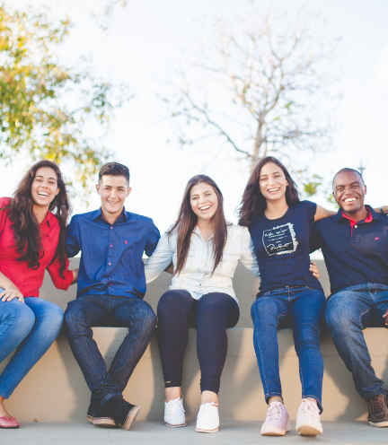 屋外のベンチで写真撮影する多国籍の仲間たち